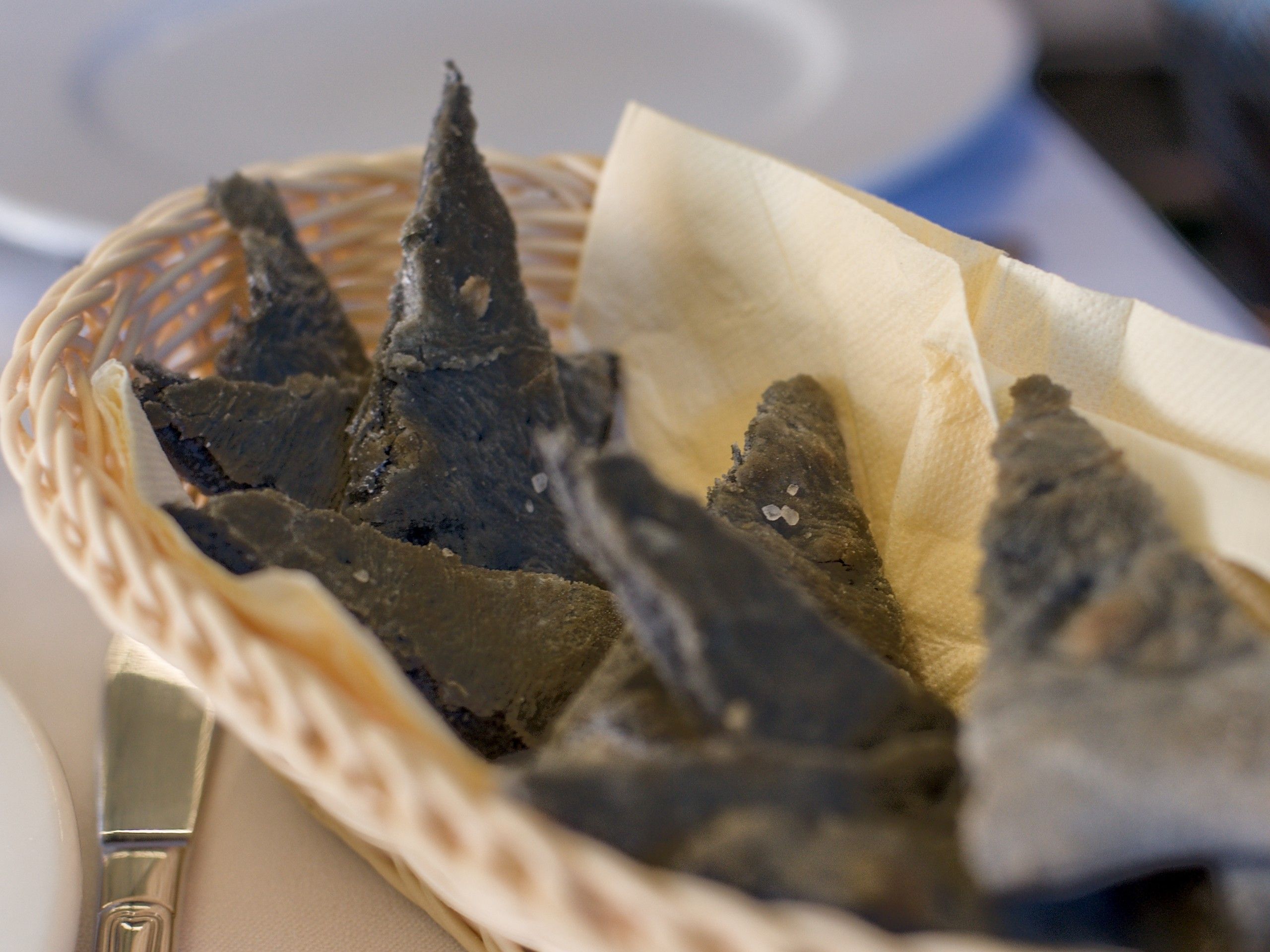 Un cestino di focaccina scura, tagliata a triangoli